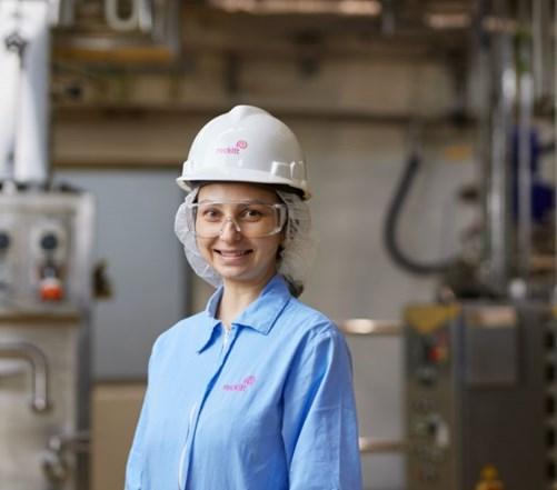 Young woman in a hard hat and goggles smiling