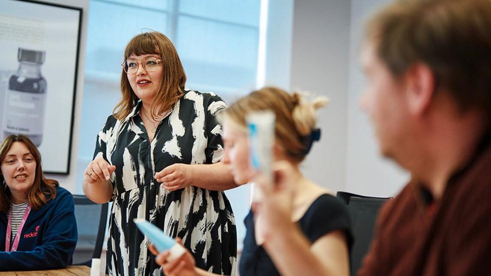 Young woman standing to speak in a meeting