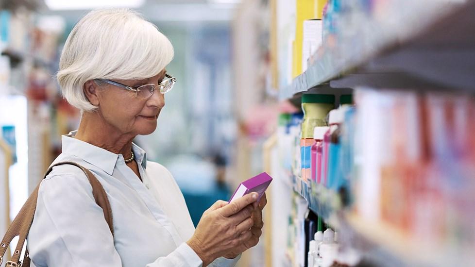 Mature woman looking at a product in a pharmacy.